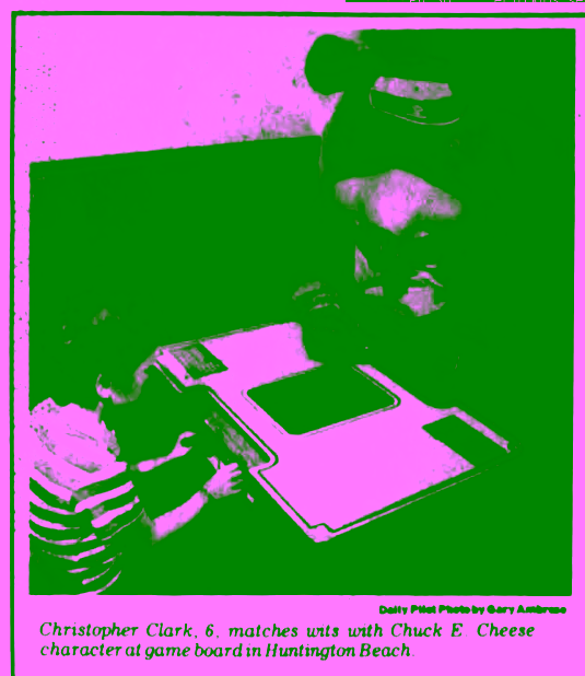 Chuck E. Cheese walkaround playing arcade game with kid.
